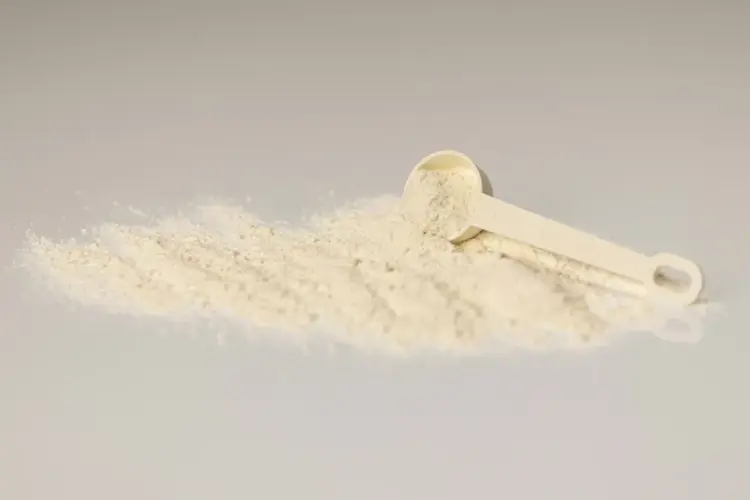Unflavoured creatine monohydrate powder with a measuring scoop